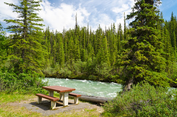 A picnic table with gorgeous view at mountain river, British Columbia, Canada.