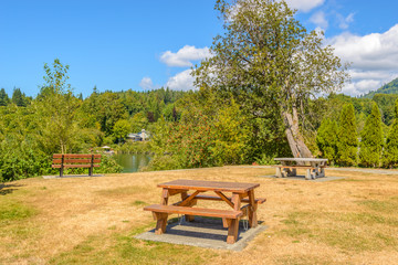 Picnic table over mountains and blue sky.