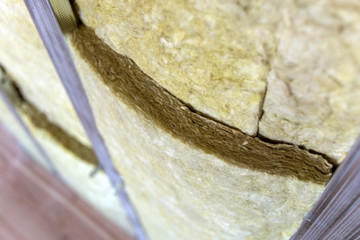 Wall of a room under renovation with mineral rock wool insulation and metal frame prepared for drywall plates.