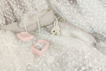 wedding concept. wedding shoes,  rings  on the background of a white veil.