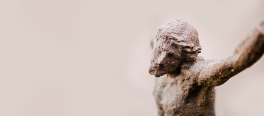 Close up fragment of destroyed ancient iron statue of the crucifixion of Jesus Christ