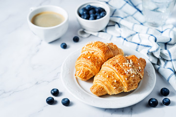 Fresh croissants with berries and cup of coffee