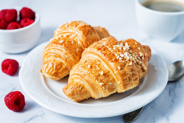 Fresh croissants with berries and cup of coffee