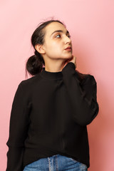 Portrait of a young and stylish middle-eastern woman in casual clothing. Attractive female posing in studio on bright background