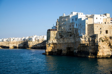 Fototapeta na wymiar White buildings on grottos and cliffs in the town of Polignano a mare in Puglia Apulia region, Southern Italy