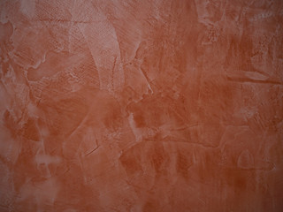 Fototapeta premium Coral painted grunge wall with bumps and scratches, modern interior decoration abstract background.