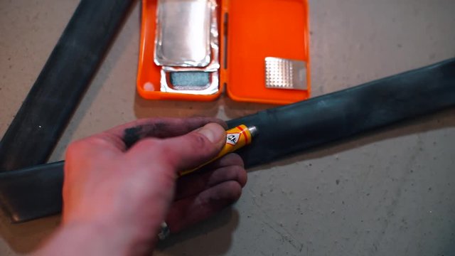 Closeup of glueing the rubber of a bicycle wheel. 
