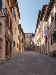 Fototapeta na wymiar Uphill street in the historic city center of Siena (Italy)