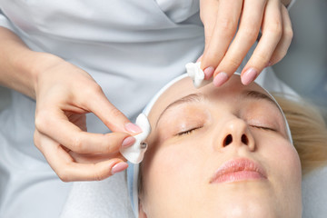Close-up beautician doctor hand making anti-age procedure, mask and peeling for young attractive female client at beauty clinic. Cosmetologist specialist doing skincare treatment .Health care therapy