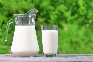 Jug and glass of milk on a wooden table