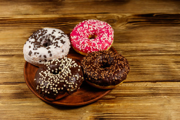 Tasty donuts on plate on a wooden table