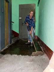 cleaning woman doing wet cleaning on the landing of an apartment building