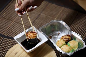 Take away sushi set on a brown background.