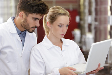 Fototapeta premium researchers in labcoats are checking the samples on laptop