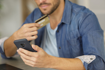Obraz na płótnie Canvas man holds a mobile phone and credit card