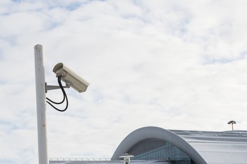 Naklejka na ściany i meble CCTV camera against a cloudy sky