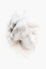 Fragment of ancient statue: face of white beautiful angel.