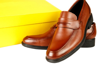 brown leather shoes with a yellow box on a white isolated background