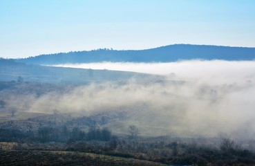 landscape with fog between hills