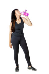 Woman in sportswear drinking water in studio