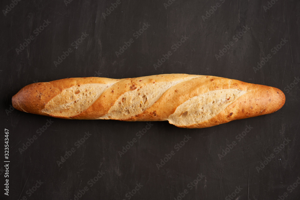 Wall mural one crispy french baguettes lie on an old wooden table with free space for text