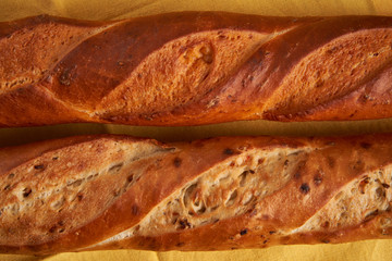 two crispy french baguettes lie on an old wooden table with free space for text