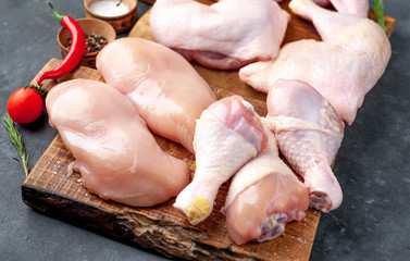 raw chicken meat with various parts of fillet, wings, thighs on concrete background