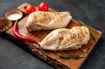 Fototapeta na wymiar grilled chicken fillet with spices on a stone background