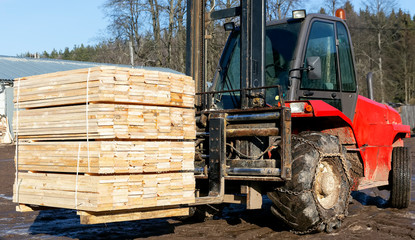 Fototapeta na wymiar The loader picks up and stacks the lumber