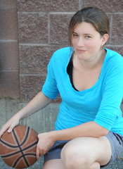 Female basketball player with her ball outside.