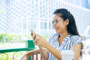 Fototapeta premium Happy woman reading message on cellphone in cafe