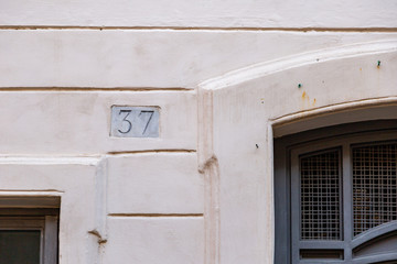 Fototapeta na wymiar number 37, ancient house number plate on brick wall, Italy