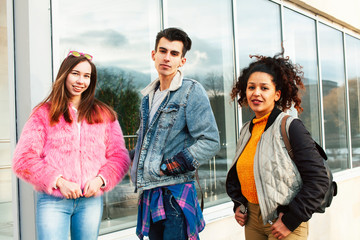 cute group of teenages at the building of university with books huggings, diversity nations real students lifestyle