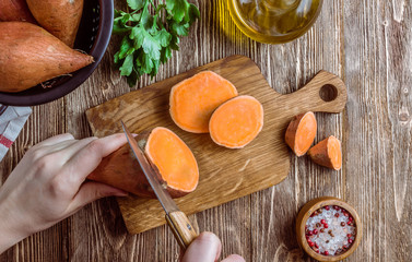 Organic farm sweet potato on rustic wooden background. Healthy eating and zero waste concept. Top...