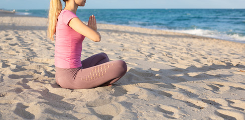  Caucasian Young Woman Doing Yoga at the Beach, Ocean on a background. Blonde hair Slim Woman in Sportswear Relaxing Outdoor. Health People Concept. Copy Space
