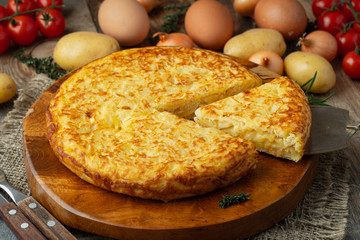 Spanish omelette with potatoes and onion, typical Spanish cuisine. Tortilla espanola. Rustic dark background. Top view