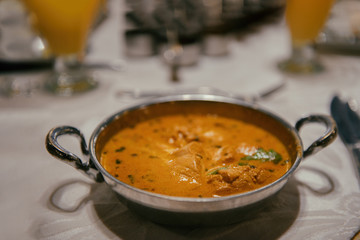 Chicken curry in a metal bowl on the table