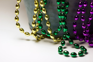 Close up view of traditional colorful Mardi Gras bead necklaces on white background with copy space
