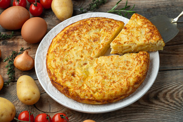 Spanish omelette with potatoes and onion, typical Spanish cuisine. Tortilla espanola. Rustic dark background. Top view