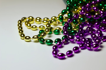 Close up view of traditional colorful Mardi Gras bead necklaces on white background with copy space
