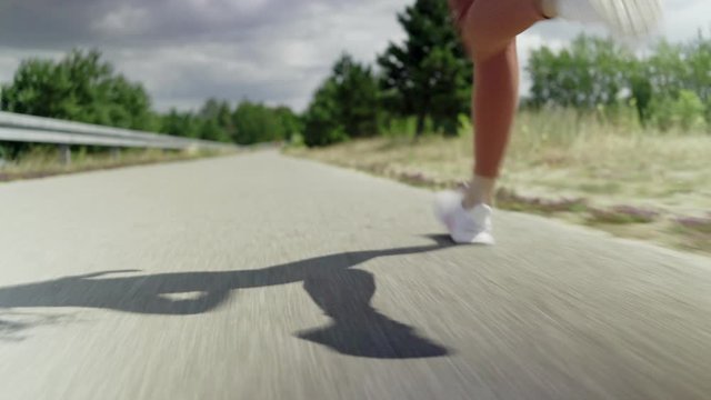 Tracking shot of woman jogging outdoors on sunny day