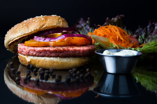 Hamburguesa de at&uacute;n con zanahoria, lechuga, cebolla y pimiento, acompa&ntilde;ada de aderezo blanco. pimienta en bola regada 