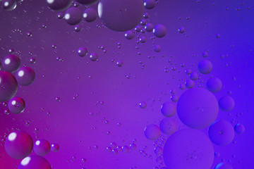 Oil drops on water surface color abstract background. blue and pink circles