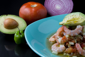 Ceviche de camarón con verduras al fondo, jitomate, cebolla, aguacate y chile habanero 