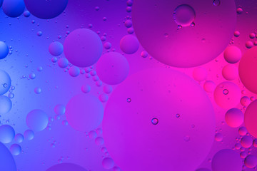 Oil drops on water surface color abstract background. blue and pink circles