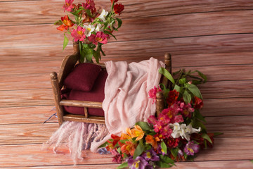 the small bed is decorated with fresh flowers. baby cot for newborn photo shoot. children's bed....