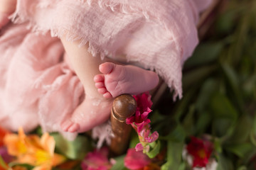 Small children's feet. Baby in a crib with flowers, fresh flowers. soft focus