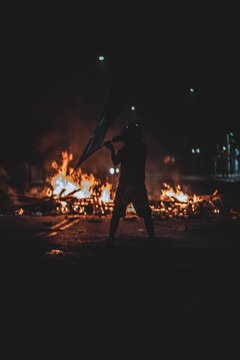  man waving night flag in protest with fire © Bastian Schofield