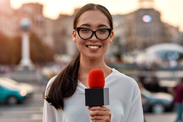 Leading the way. TV reporter presenting the news outdoors. Journalism industry, live streaming...