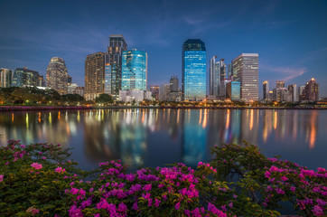 Lake with Purple Flowers in City Park under Skyscrapers at Twilight. Benjakiti Park in Bangkok, Thailand